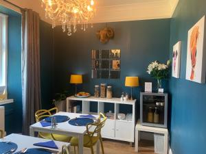 托伯莫里Burnbank BnB的一间拥有蓝色墙壁和桌椅的用餐室