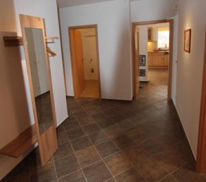 克林克HAUS MUeRITZBRISE _ EG_Fewo的走廊设有两扇门,铺有瓷砖地板