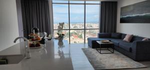 都拉斯Durres City Apartment, City center & close to the beach的客厅设有蓝色的沙发和大窗户