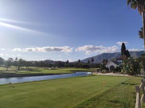 马拉加HAPPY HOLIDAYS的享有带池塘的高尔夫球场的景色