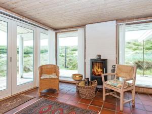 维泽桑讷5 person holiday home in Hvide Sande的客厅设有壁炉、椅子和窗户