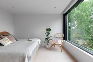 斯德哥尔摩Swedish Elegance & Luxury Home的一间卧室设有一张床和一个大窗户