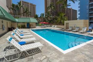 檀香山威基基瑞曼达酒店的一组躺椅和一个游泳池