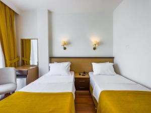 费特希耶Dedeoğlu Port Hotel的配有黄色床单的酒店客房的两张床