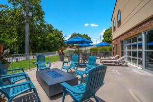 伊丽莎白镇SureStay Plus Hotel by Best Western Elizabethtown Hershey的一个带蓝色桌椅和蓝色遮阳伞的庭院