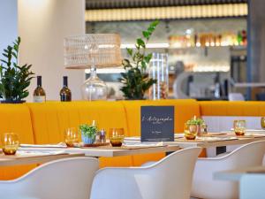 穆耶龙·勒卡普蒂夫ibis Styles La Roche-sur-Yon的一间带桌椅和葡萄酒瓶的餐厅