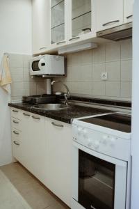 Gornja ToplicaApartman Hana的白色的厨房设有水槽和炉灶。