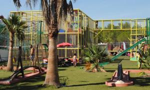 阿尔让河畔皮热6/8 pax COTTAGE - Oasis Village的一个带滑梯和棕榈树游乐场的公园