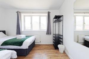 KentComfortable Home in Kent, Sleeps 6 - Parking Available的一间卧室设有两张床和两个窗户。