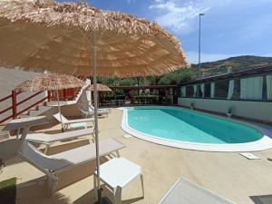 Monastir守护神酒店的一个带椅子和遮阳伞的游泳池