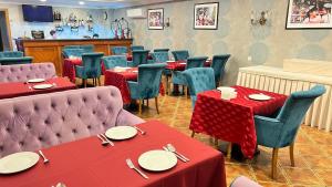 KokandSilk Road Kokand Hotel的餐厅配有桌椅和红色桌布