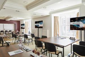 杜伦Delta Hotels by Marriott Durham Royal County的一间会议室,配有桌椅和投影屏幕