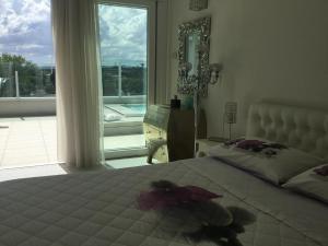 米萨诺阿德里亚蒂科Suite Luxury Seaview的一间卧室设有一张大床和一个大窗户