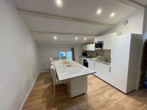 里耶Duplex sous les toits的厨房配有白色橱柜和桌椅