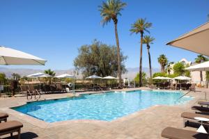 兰乔米拉日The Westin Mission Hills Resort Villas, Palm Springs的度假村的游泳池配有椅子和遮阳伞