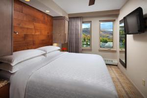 埃文Sheraton Mountain Vista Villas, Avon / Vail Valley的卧室设有一张白色大床和一扇窗户。