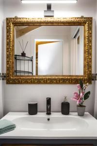 基亚瓦里La CASETTA Antica dimora nel centro storico的浴室水槽上方设有金色镜子