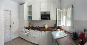 德尼亚La Duna de Denia的厨房配有白色橱柜和水槽