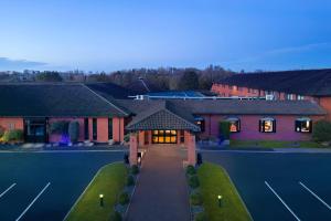 北安普敦Delta Hotels by Marriott Northampton的享有带网球场的房屋的空中景致