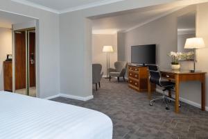 北安普敦Delta Hotels by Marriott Northampton的酒店客房配有一张床、一张书桌和一台电视。