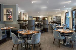 北安普敦Delta Hotels by Marriott Northampton的一间带桌椅的餐厅和一间酒吧
