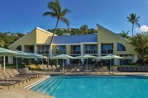 圣约翰The Westin St. John Resort Villas的一个带椅子和遮阳伞的游泳池的度假酒店