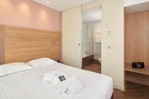 巴黎希维内酒店的卧室配有白色床和毛巾