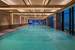 西安西安浐灞喜来登酒店的一座大型游泳池,位于一座带窗户的建筑内