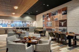 艾伦Marriott Dallas Allen Hotel & Convention Center的一间带桌椅的餐厅和一间厨房