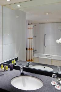 泰恩河畔纽卡斯尔Delta Hotels by Marriott Newcastle Gateshead的一间带两个盥洗盆和大镜子的浴室