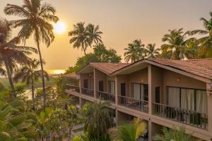曼德姆里瓦海滩度假酒店的棕榈树海滩上的房子