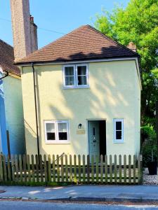 Sway3-bed cottage in Sway, New Forest (5 min walk from Sway Train Station)的白色的小房子,设有木栅栏
