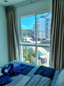 梅尔皮姆Grandblue 311的一间卧室设有窗户和一张蓝色床单。