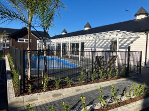 罗托鲁瓦Newina Rotorua的房屋前设有游泳池的围栏