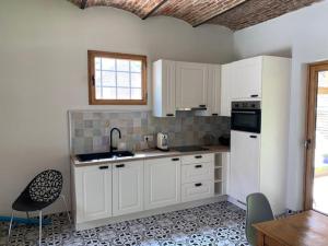 圣利芬斯－豪特姆Paardenhuisje的厨房配有白色橱柜和桌椅