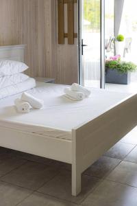 索洛特维诺Lotus & Spa的一张白色的大床,上面有白色的毛巾