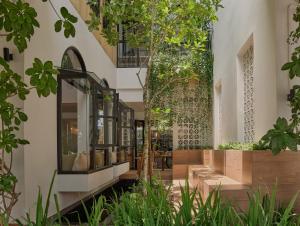 尖竹汶The Motifs Eco Hotel - SHA Extra Plus的一座带树木和植物庭院的建筑