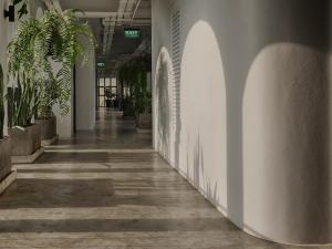 尖竹汶The Motifs Eco Hotel - SHA Extra Plus的墙上挂着植物的办公室里空的走廊