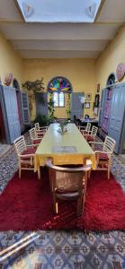 拉腊什La Maison Haute Larache Morocco的红色地毯上的带桌椅的用餐室
