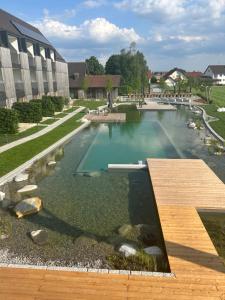BalzhausenHotel Lenderstuben的一个带木制甲板和水的大型游泳池