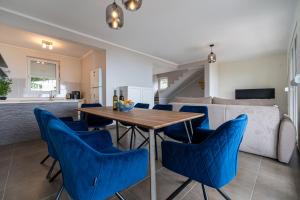 布德瓦Villas Monte Hill的厨房以及带木桌和蓝色椅子的客厅。