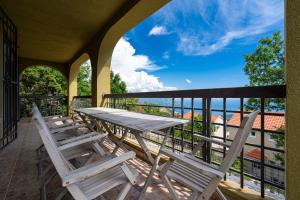 布德瓦Villas Monte Hill的阳台的门廊配有桌椅