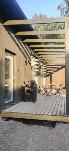 海门林纳New Villa w/sauna, jacuzzi &wifi的木制甲板上配有桌椅