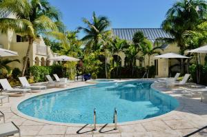 The Bight SettlementsBungalows at Windsong on the Reef的一个带椅子和棕榈树的大型游泳池