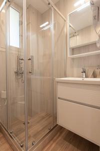 OinófitaBukovo Apartment的一间带玻璃淋浴和水槽的浴室