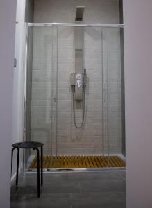 波坦察La Piazzetta Suite的浴室设有玻璃门和凳子淋浴