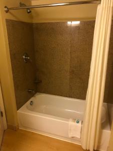 杰克逊维尔MainStay Suites Jacksonville near Camp Lejeune的带浴缸和淋浴帘的浴室