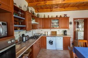 MonostorapátiVölgykapu Vendégház的厨房配有木制橱柜、洗衣机和烘干机