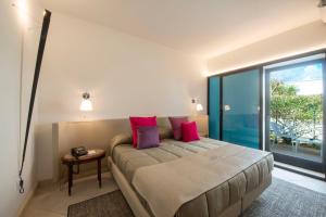 奥斯图尼玛赛丽亚圣塔卢西亚大酒店的卧室配有一张带粉红色枕头的大床