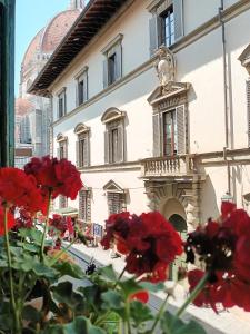 佛罗伦萨Duomo Suites Florence的一群红色的花在建筑物前